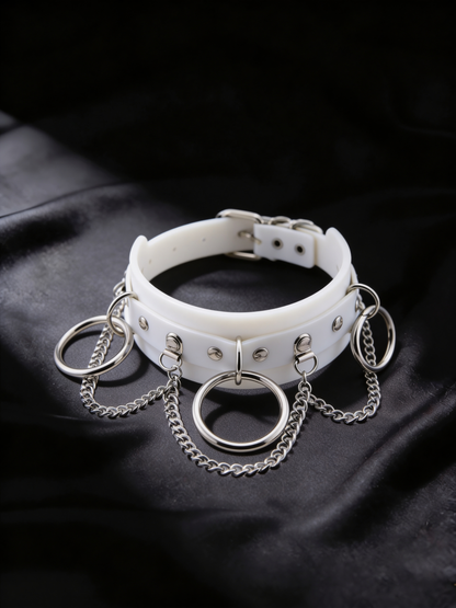 The Trinity white leather choker with three silver O-rings and draped chains, flat lay, Chokerz